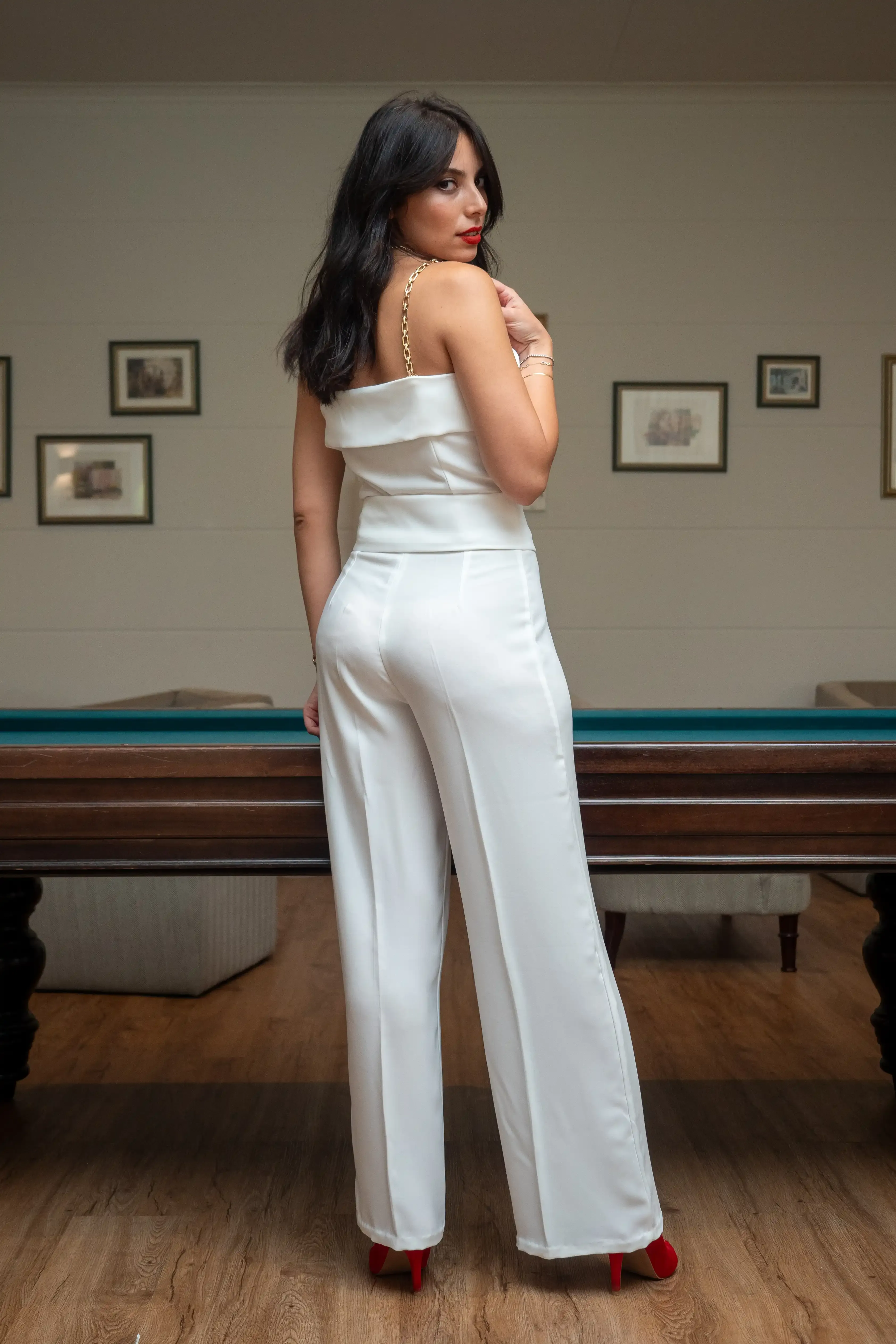 Uma mulher posa com um macacão branco elegante
